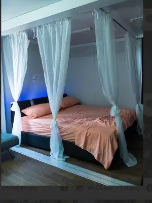 a bed with white drapes in a bedroom at Villa María 2 in Bonao