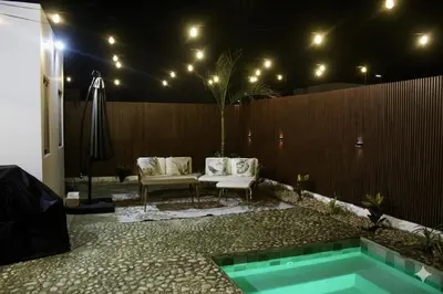 a backyard with a pool and a fence and a table and chairs at Casaè Rojas Presents Golden Oasis in Punta Cana