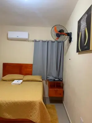a bedroom with a bed and a fan at Hotel los 4 Tesoros in Pedernales