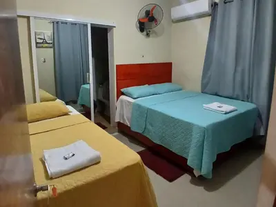a hotel room with two beds and a mirror at Hotel los 4 Tesoros in Pedernales