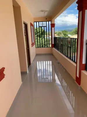 a hallway of a house with a balcony with windows at Hotel los 4 Tesoros in Pedernales