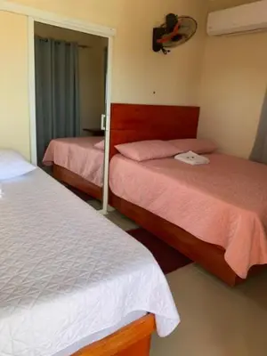 a bedroom with two beds and a mirror at Hotel los 4 Tesoros in Pedernales