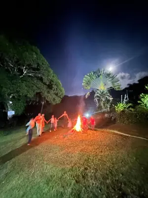 a group of people around a fire in a field at Casa de Campo Vive in Ensanche Savica de Mendoza