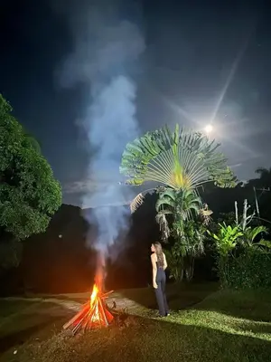 a woman standing next to a bonfire at night at Casa de Campo Vive in Ensanche Savica de Mendoza