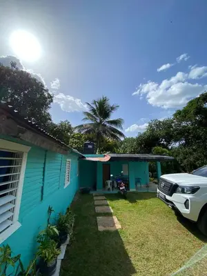 a car parked in front of a blue house at Casita de Campo VIVE in Pedro Brand