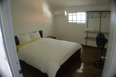 a bedroom with a bed with white sheets and a window at Villa Emili in Las Terrenas