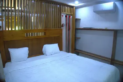 a bedroom with a white bed with a wooden headboard at Villa Emili in Las Terrenas