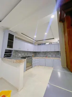 a large kitchen with white cabinets and a ceiling at Villa Emili in Las Terrenas