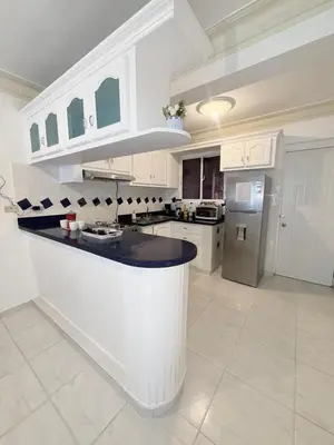 a kitchen with white cabinets and a black counter top at Residencial Marvin I Apartamento 1A in Santiago de los Caballeros