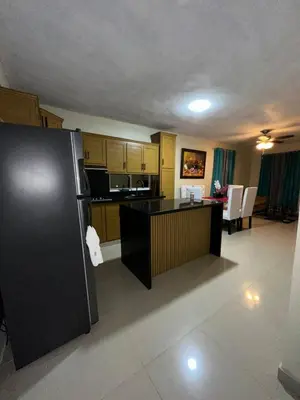 a kitchen with a black refrigerator and a table at Rincón Paraíso Cheché in Dajabón
