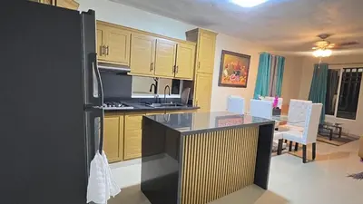 a kitchen with a black refrigerator and a dining room at Rincón Paraíso Cheché in Dajabón