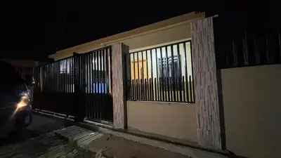 a fence on the side of a building at night at Rincón Paraíso Cheché in Dajabón