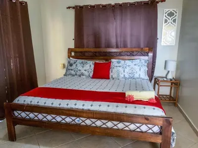 a bed with a wooden headboard in a room at Villa 17M in Sosúa
