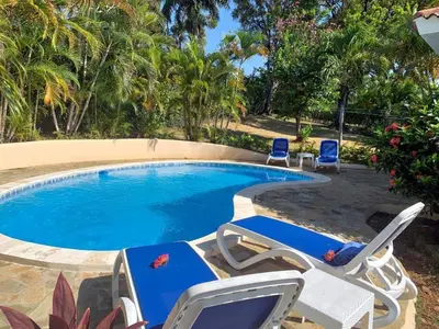 a swimming pool with two lawn chairs and a swimming pool at Villa 17M in Sosúa