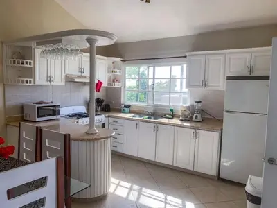 a kitchen with white cabinets and a white refrigerator at Villa 17M in Sosúa