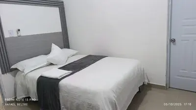 a bedroom with a bed with white sheets and pillows at Sol y Arena in Pedernales