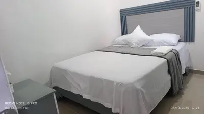 a bedroom with a bed with white sheets and pillows at Sol y Arena in Pedernales