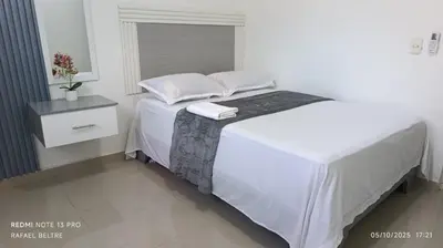 a white bed with two pillows on top of it at Sol y Arena in Pedernales