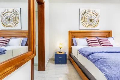 a bedroom with two beds and a mirror at Quiet 1-Bedroom Apartment with Pool View in Gated Bávaro Residence in Punta Cana