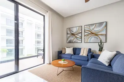 a living room with a blue couch and a table at Quiet 1-Bedroom Apartment with Pool View in Gated Bávaro Residence in Punta Cana