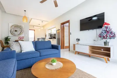 a living room with a blue couch and a christmas tree at Quiet 1-Bedroom Apartment with Pool View in Gated Bávaro Residence in Punta Cana