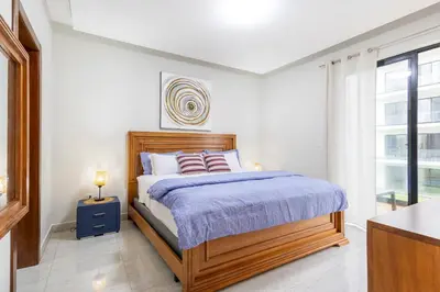 a bedroom with a wooden bed and a window at Quiet 1-Bedroom Apartment with Pool View in Gated Bávaro Residence in Punta Cana