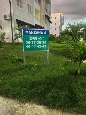 a sign in the grass in front of a building at Los manglares in La Cana