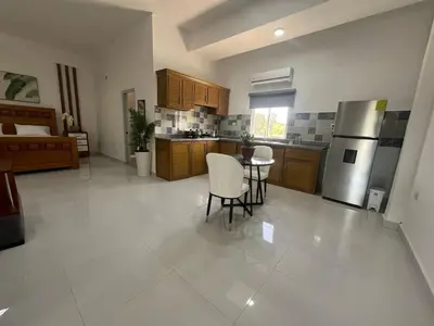 a large kitchen with a table and a refrigerator at Hotel Altos de la Montaña in Colonia Japonesa