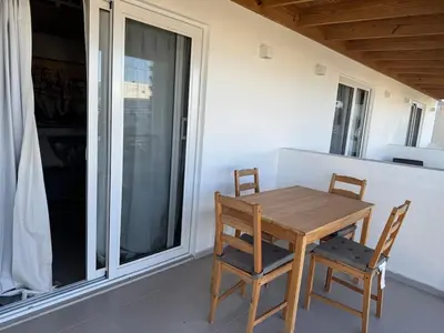 a wooden table and two chairs on a balcony at Apartment bayahibe in Bayahibe