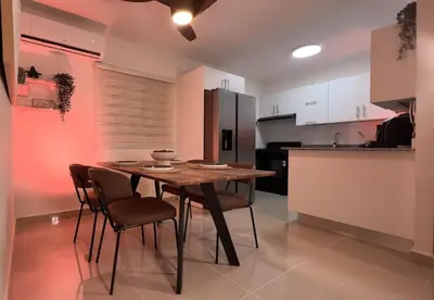 a kitchen with a wooden table and chairs in a room at San Isidro Urban Suite in Juan López