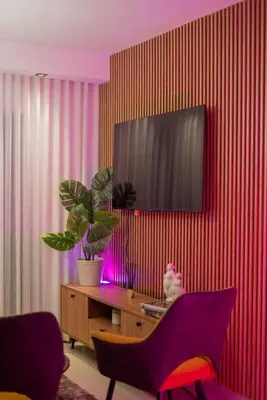 a living room with a tv on a red wall at San Isidro Urban Suite in Juan López
