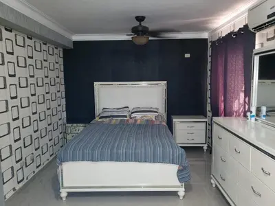 a bedroom with a bed and a black wall at Getaway paradise in Los Mameyes