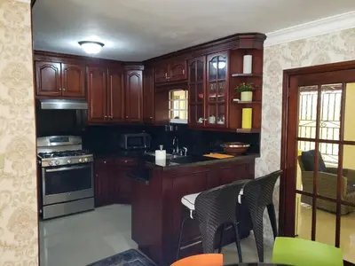 a kitchen with wooden cabinets and a table with chairs at Getaway paradise in Los Mameyes