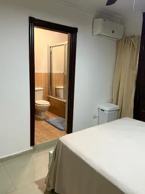 a bedroom with a bed and a bathroom with a toilet at Getaway paradise in Los Mameyes