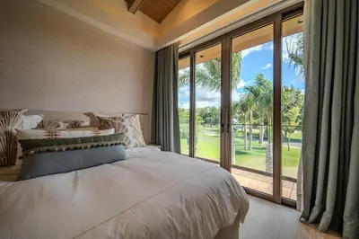 a bedroom with a large bed and a large window at Luxury Guesthouse Villa with Golf Cart - Casa de Campo in La Romana