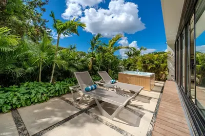 a patio with two chairs and a tub on a porch at Luxury Guesthouse Villa with Golf Cart - Casa de Campo in La Romana