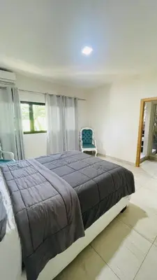 a bedroom with a large bed and a blue chair at oceanfront apartment in La Puntica de Juan Dolio