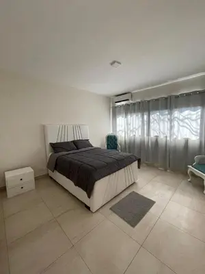 a bedroom with a bed and a large window at oceanfront apartment in La Puntica de Juan Dolio