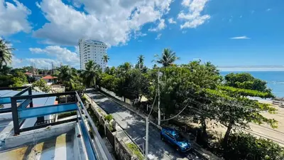 a balcony with a view of a beach and a car at oceanfront apartment in La Puntica de Juan Dolio