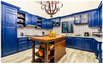 a blue kitchen with a island with fruit on it at Luxury Awaits at Casa de Campo A Stunning Five-Bedroom Retreat in La Romana