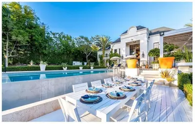 a dining table and chairs next to a swimming pool at Luxury Awaits at Casa de Campo A Stunning Five-Bedroom Retreat in La Romana