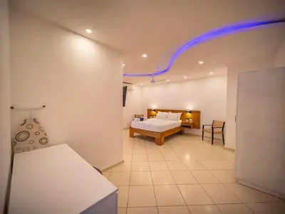 a bedroom with a bed and a room with a couch at Plaza Achim 2BR APT heart of nightlife area in Sosúa