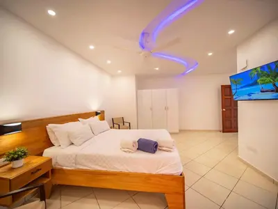 a bedroom with a bed and a ceiling fan at Plaza Achim 2BR APT heart of nightlife area in Sosúa