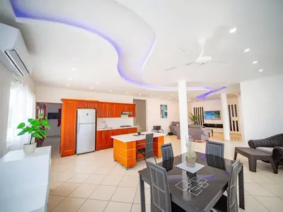 a living room with a kitchen and a dining room at Plaza Achim 2BR APT heart of nightlife area in Sosúa