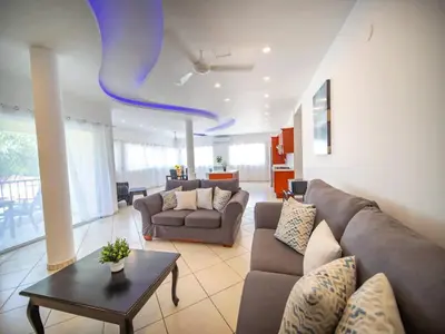 a living room with a couch and a table at Plaza Achim 2BR APT heart of nightlife area in Sosúa
