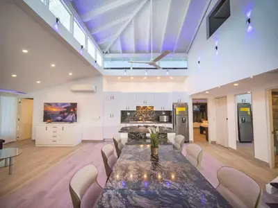 a large dining room with a table and a kitchen at Luxury 3BR Penthouse 300m from beach in Sosúa