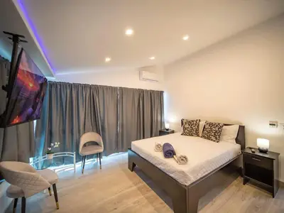 a bedroom with a large bed and a chair at Luxury 3BR Penthouse 300m from beach in Sosúa