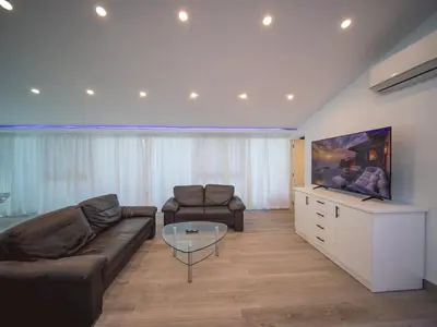 a living room with a couch and a flat screen tv at Luxury 3BR Penthouse 300m from beach in Sosúa