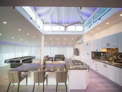 a kitchen with a table and chairs in a room at Luxury 3BR Penthouse 300m from beach in Sosúa