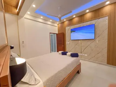 a bedroom with a bed and a tv on a wall at Plaza Achim 7 Luxury Apt 250m from Sosua Beach in Sosúa